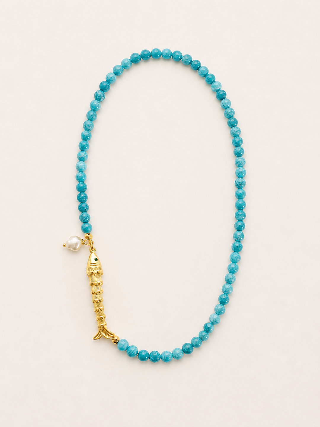 Turquoise beaded necklace with a gold fish and a pearl accent.  