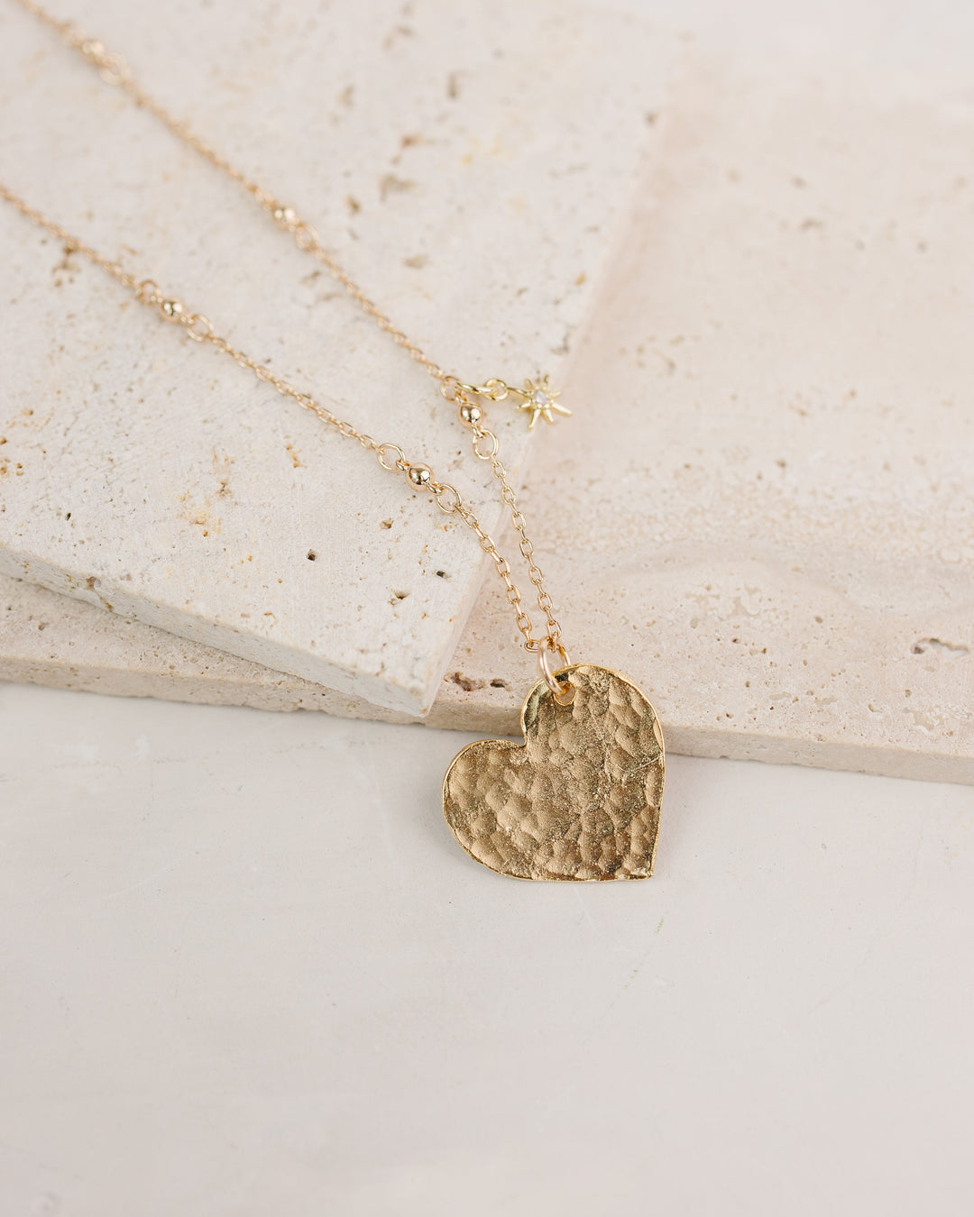Gold heart-shaped pendant necklace on a light background