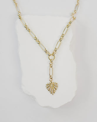 Gold necklace with a starburst pendant on a white background